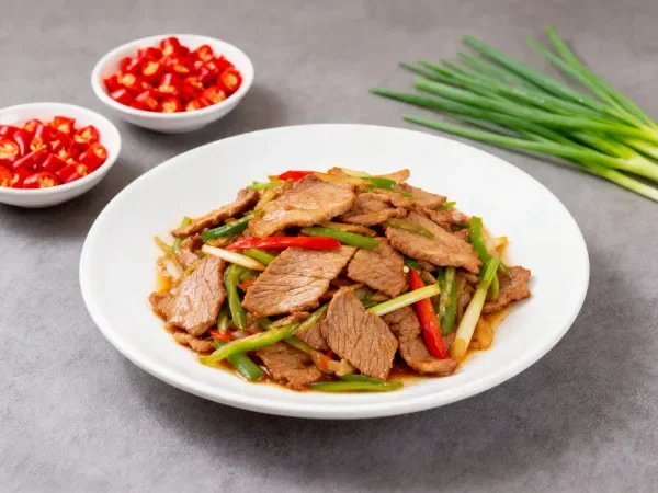 青蒜辣椒炒牛肉在白色圆盘上的展示