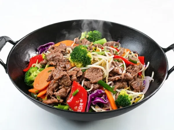 牛肉时蔬小炒色泽鲜亮,肉片纹理清晰,搭配多种蔬菜,处于烹饪状态的特写画面。