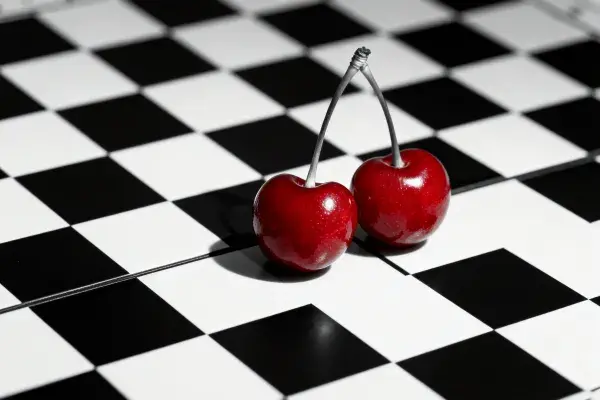 两颗樱桃置于黑白棋盘格表面
