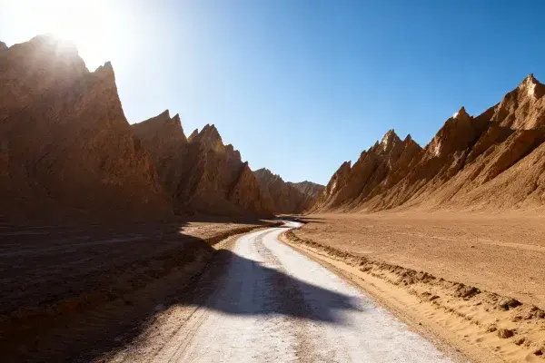 阳光下雅丹地貌间的道路景观
