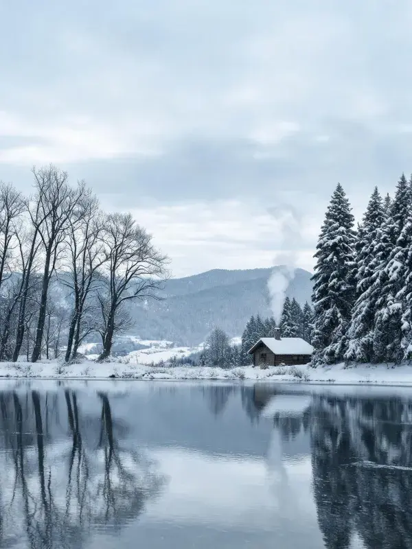 雪覆山林湖畔木屋冬景