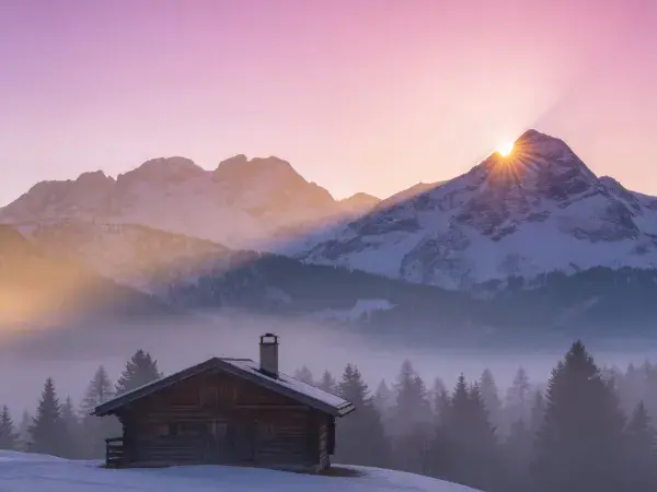山地雪原中的木质农舍晨景