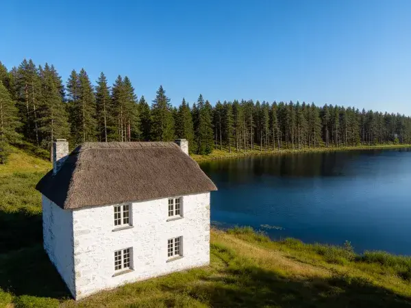 湖畔石砌茅草屋顶住宅景观