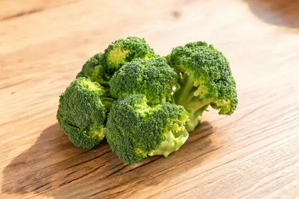 木质桌面上的新鲜西兰花特写