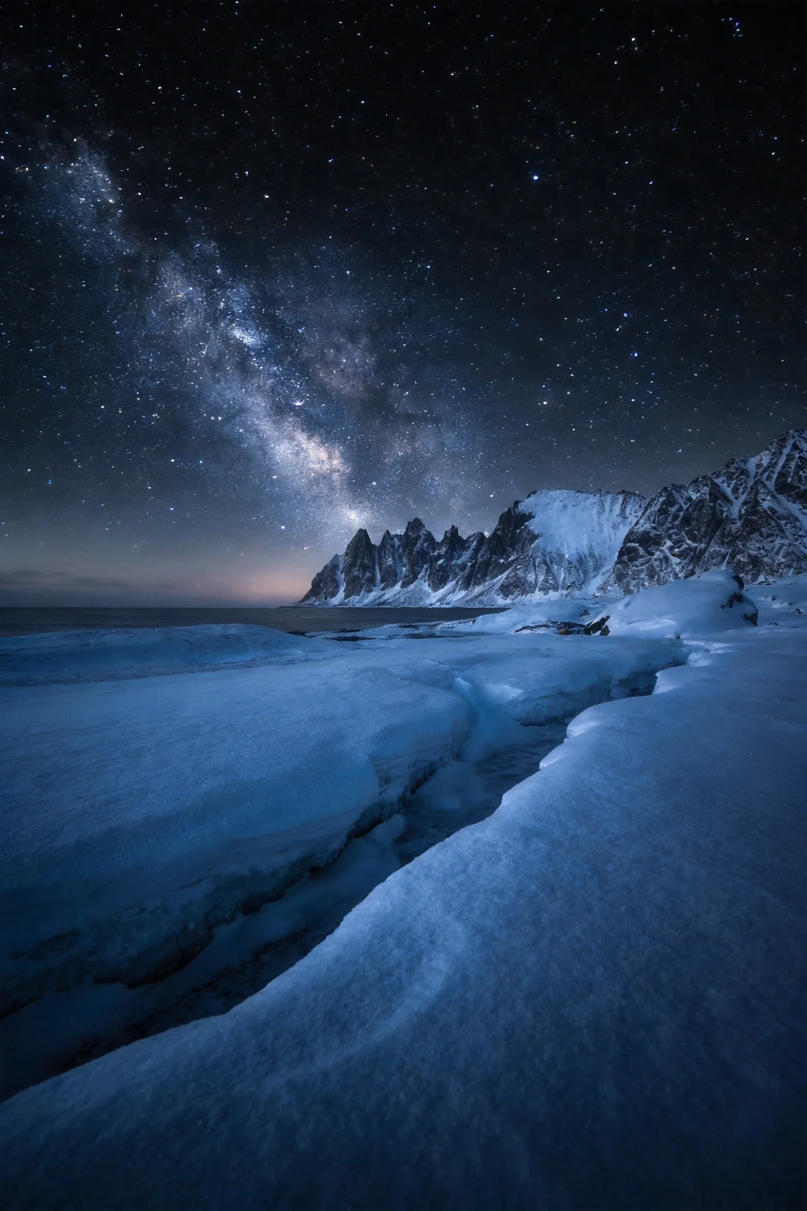 北极雪山海岸星空夜景中，洁白的冰雪覆盖地面，冰面纹理清晰，远处是陡峭的雪山山峰，夜空中星河闪耀。