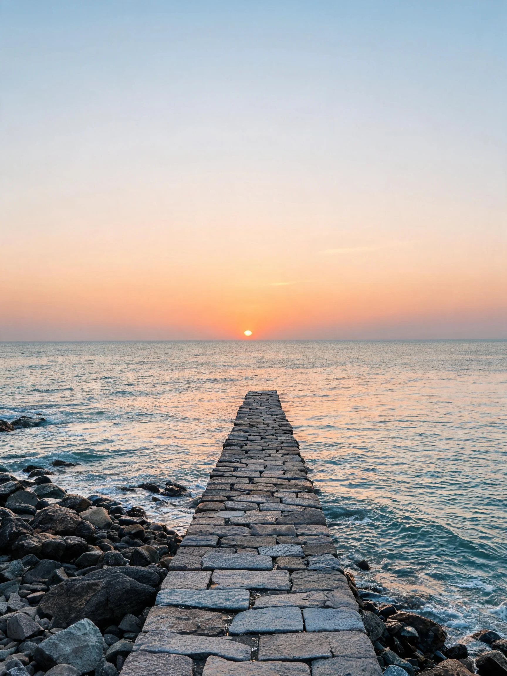 海滨石砌栈桥延伸至远方,海水轻拍石缝,天空呈现橙红色渐变,石板路由不规则矩形石块构成,海水湿润气息明显。