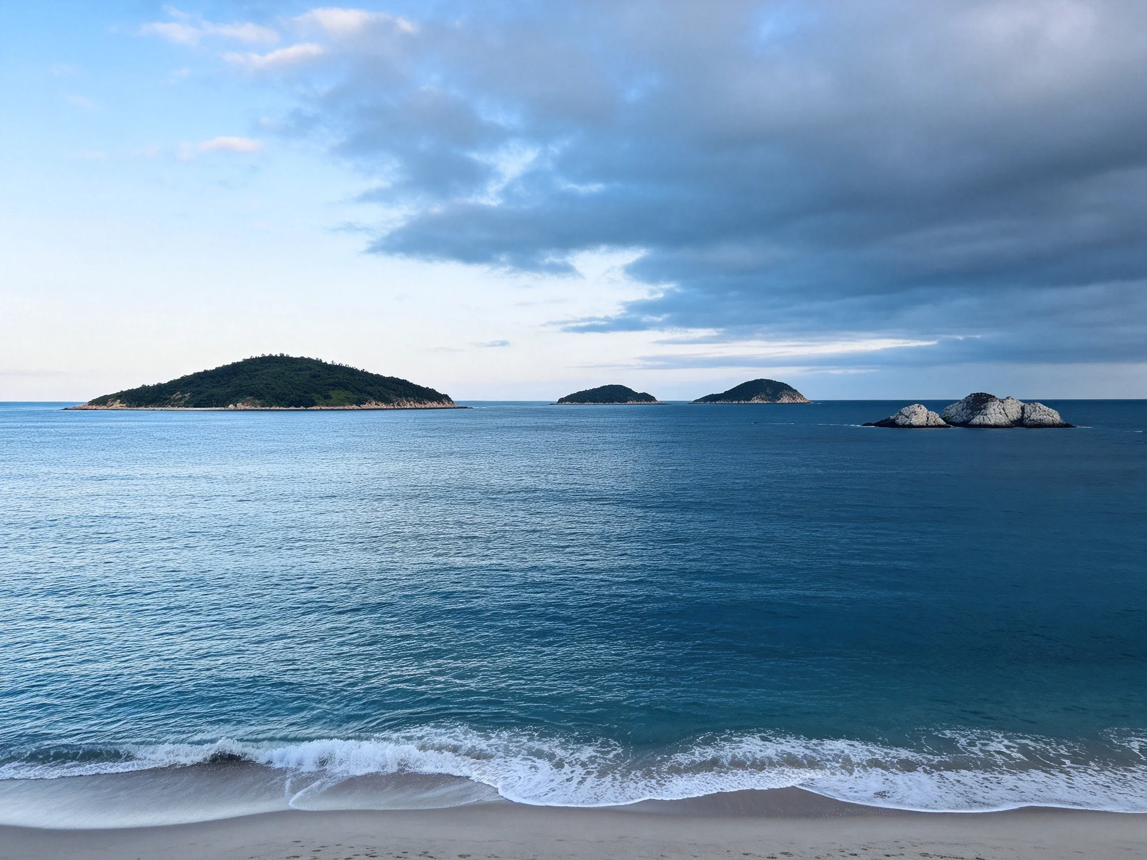 海湾岛屿群中水呈现出清澈蓝蓝绿色,波浪轻柔地拍打着岸边,水面表面有明显的波纹纹理。