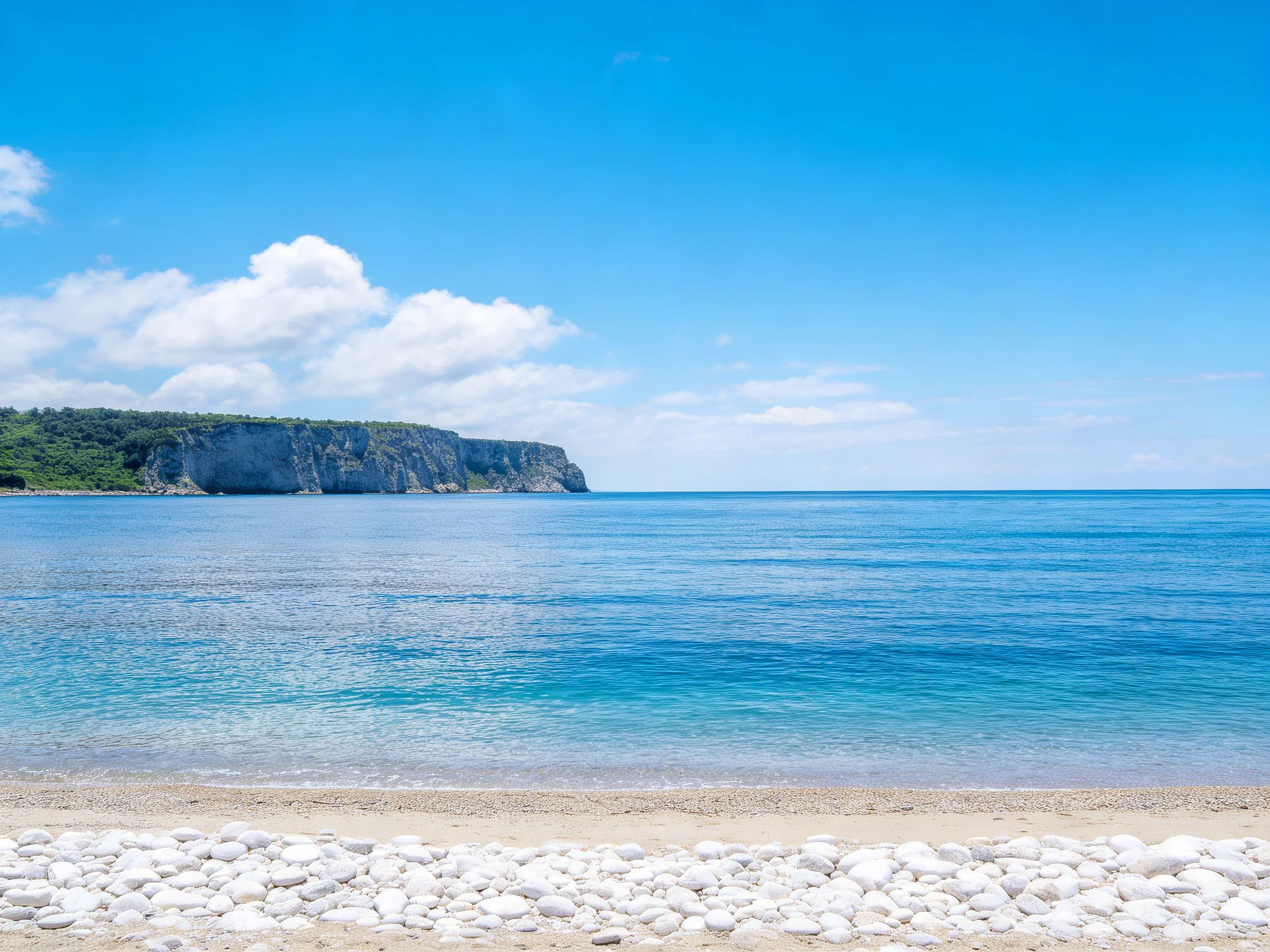 海岸峭壁风光展现出了鹅卵石的圆润形态与清澈蓝色海水纹理。